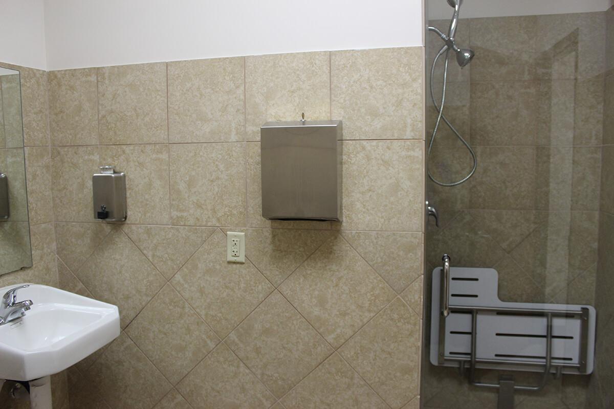 ADA-accessible patient restroom with grab bars and roll-in shower